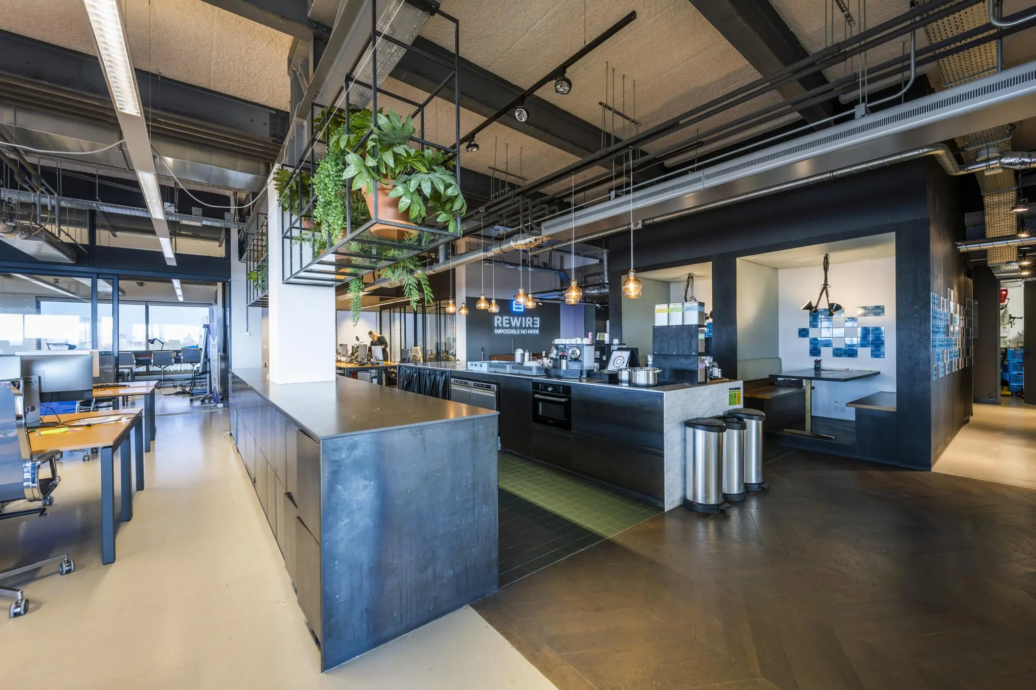 Moderne kantoorruimte aan de Vijzelstraat met open werkplekken, een industriële keuken en zithoeken.