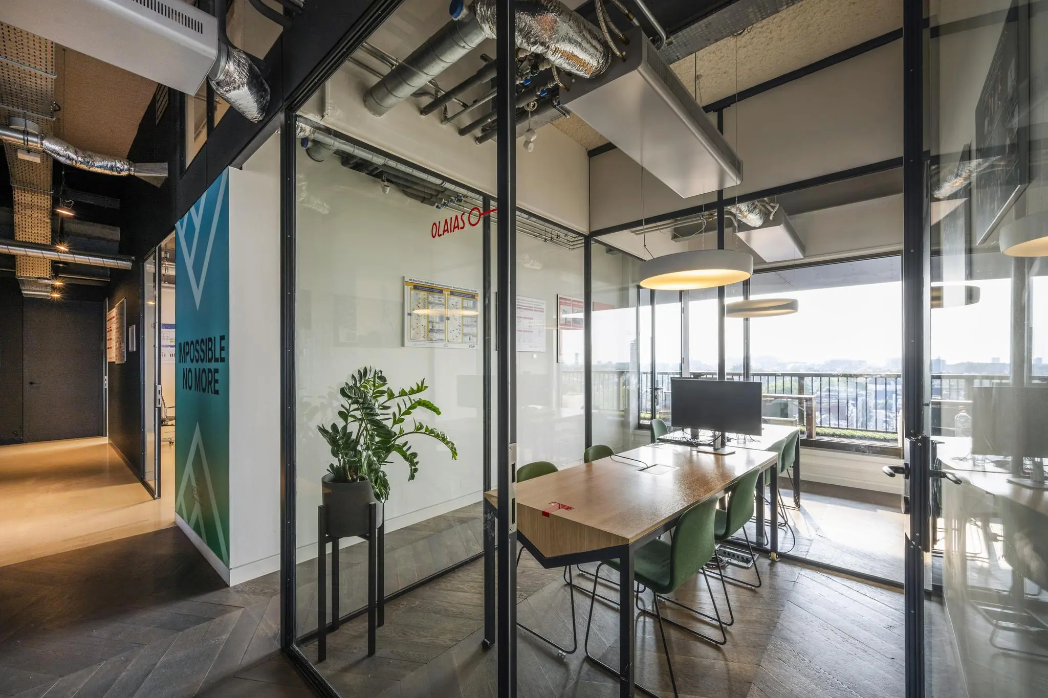 Moderne vergaderruimte in een glazen kantoorkamer aan de Vijzelstraat met uitzicht over de stad.