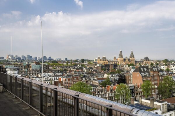 Uitzicht vanaf de Vijzelstraat over Amsterdam met het Rijksmuseum prominent in beeld.