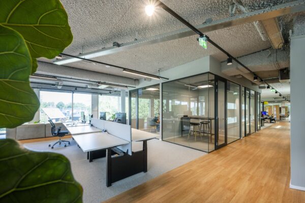 Moderne kantooretage aan het John M. Keynesplein met glazen vergaderruimtes, open werkplekken en veel daglicht.