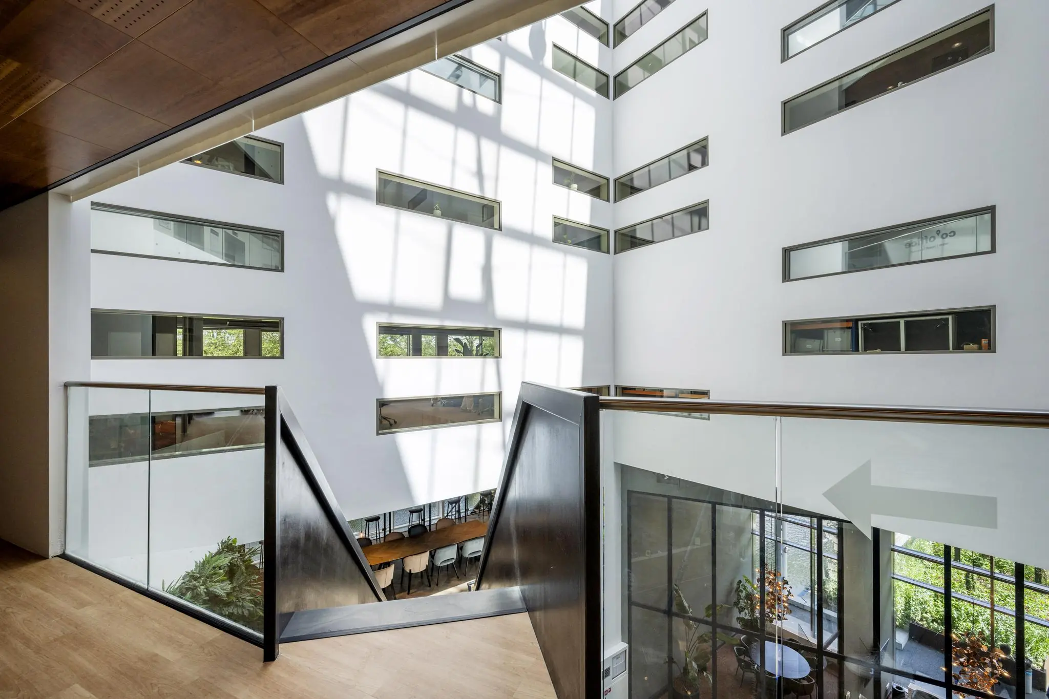 Licht atrium met moderne glazen balustrades in het John M. Keynesplein-gebouw.