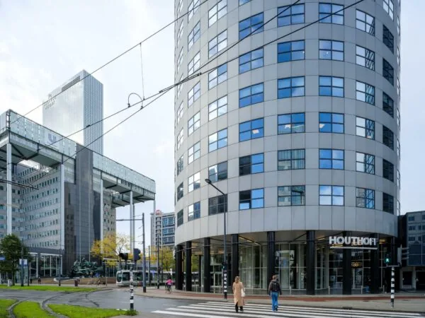 Kantoorgebouw Houthoff aan het Weena in Rotterdam met voetgangers en een passerende tram.