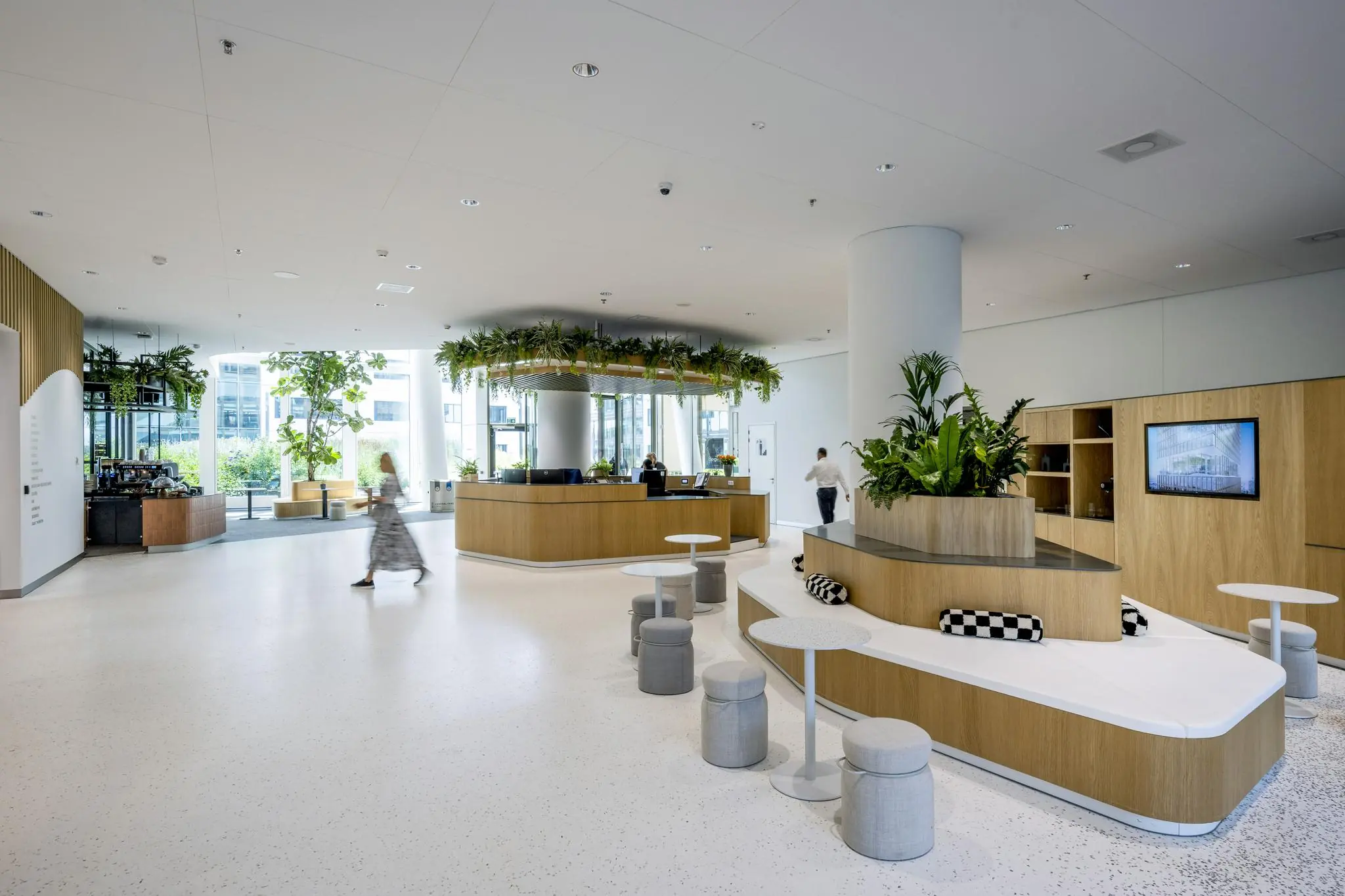Modern en licht interieur van het Stadsplateau met zitplekken, veel groen en een receptiebalie.