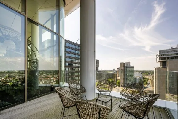 Modern dakterras met rotanstoelen en uitzicht over het Stadsplateau in Utrecht.
