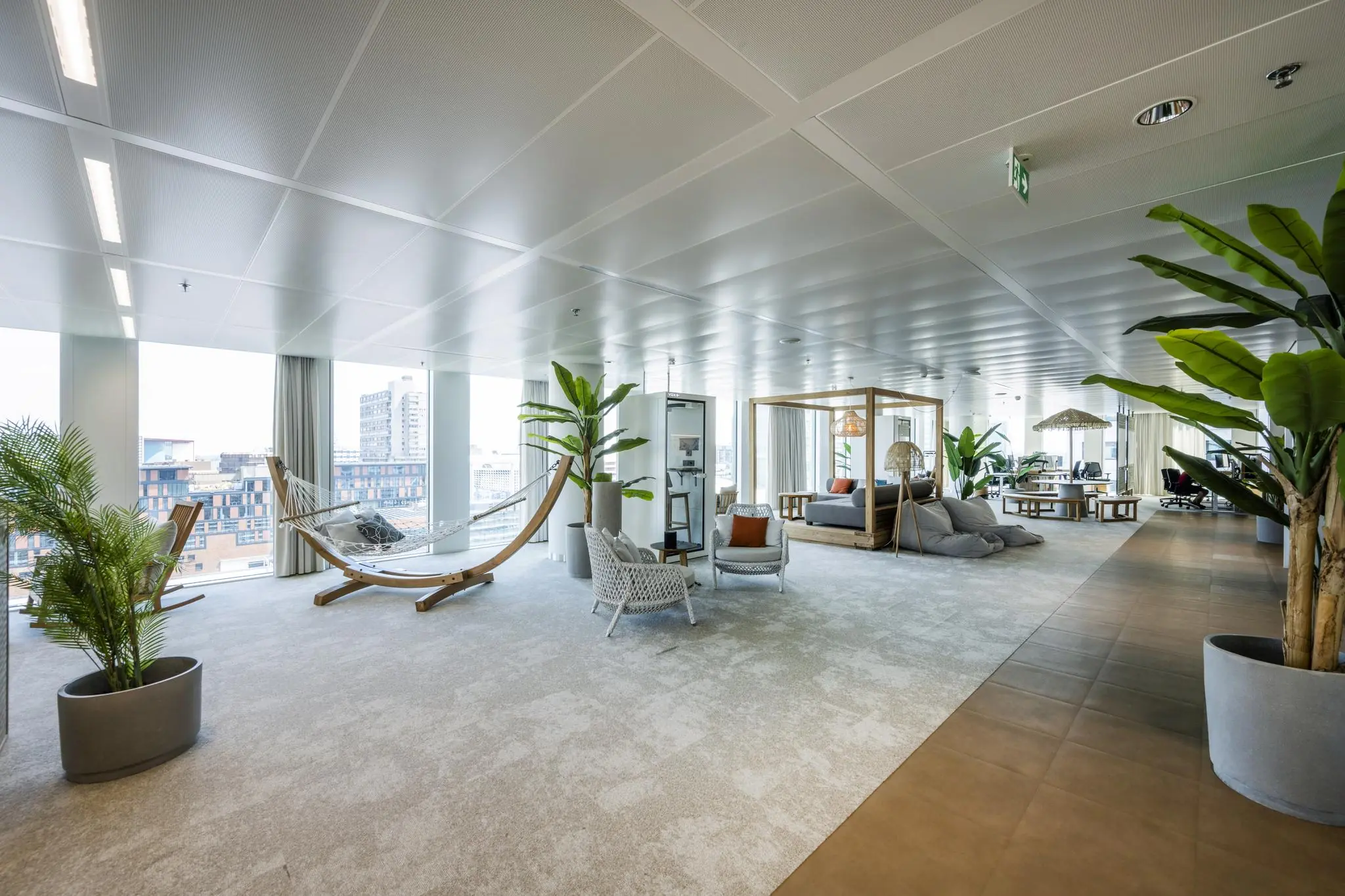 Modern en licht kantoorpand op het Stadsplateau met loungemeubels, planten en uitzicht op de stad.