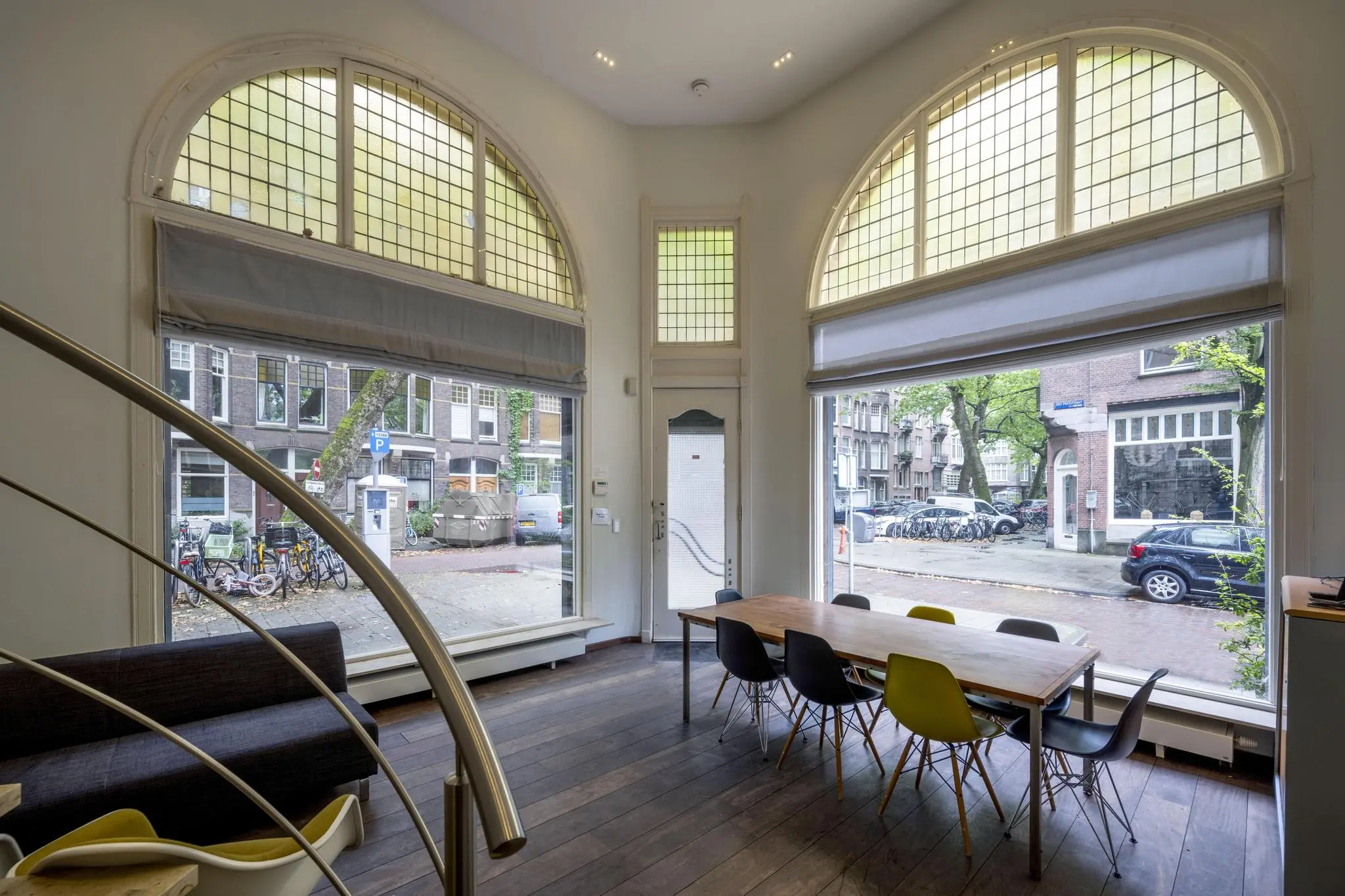 Interieur van een modern woonhuis aan de Lomanstraat met grote ramen, hoge plafonds en uitzicht op een Amsterdamse straat.