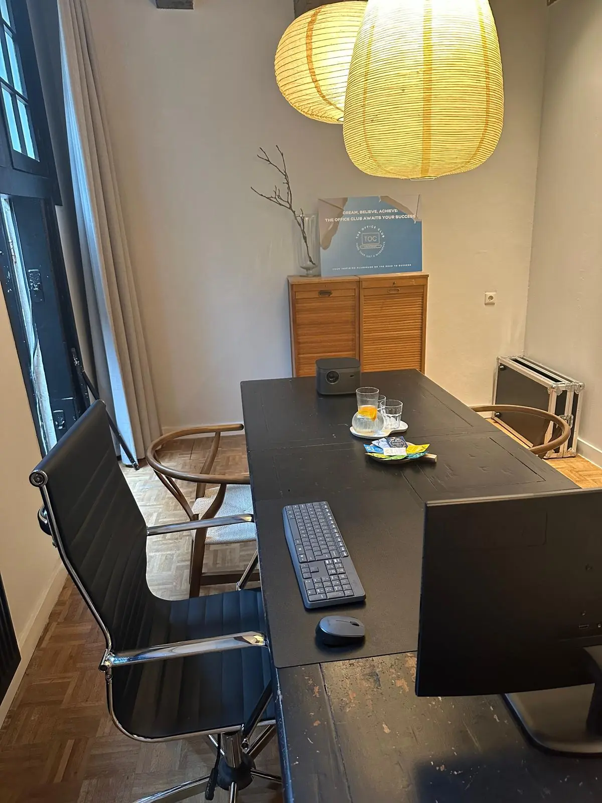 Modern ingerichte vergaderruimte aan de Herengracht met bureau, computerscherm en sfeervolle verlichting.