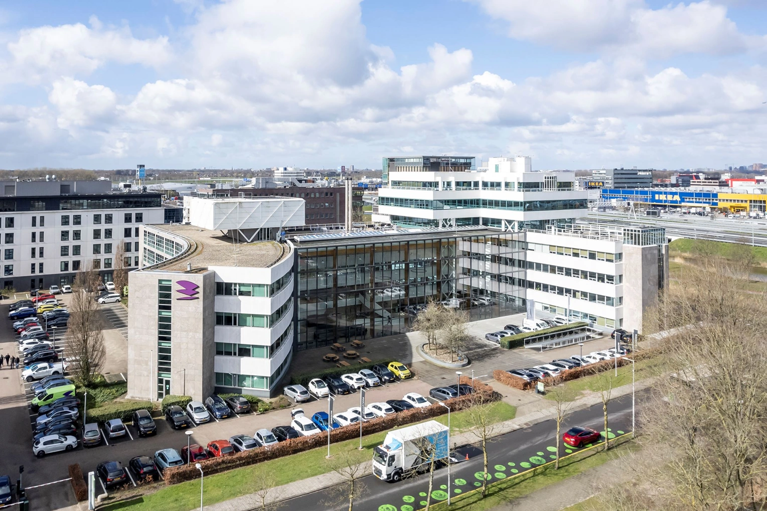 Kantoorgebouw aan de Paalbergweg in Amsterdam met parkeergelegenheid en herkenbaar logo op de gevel.
