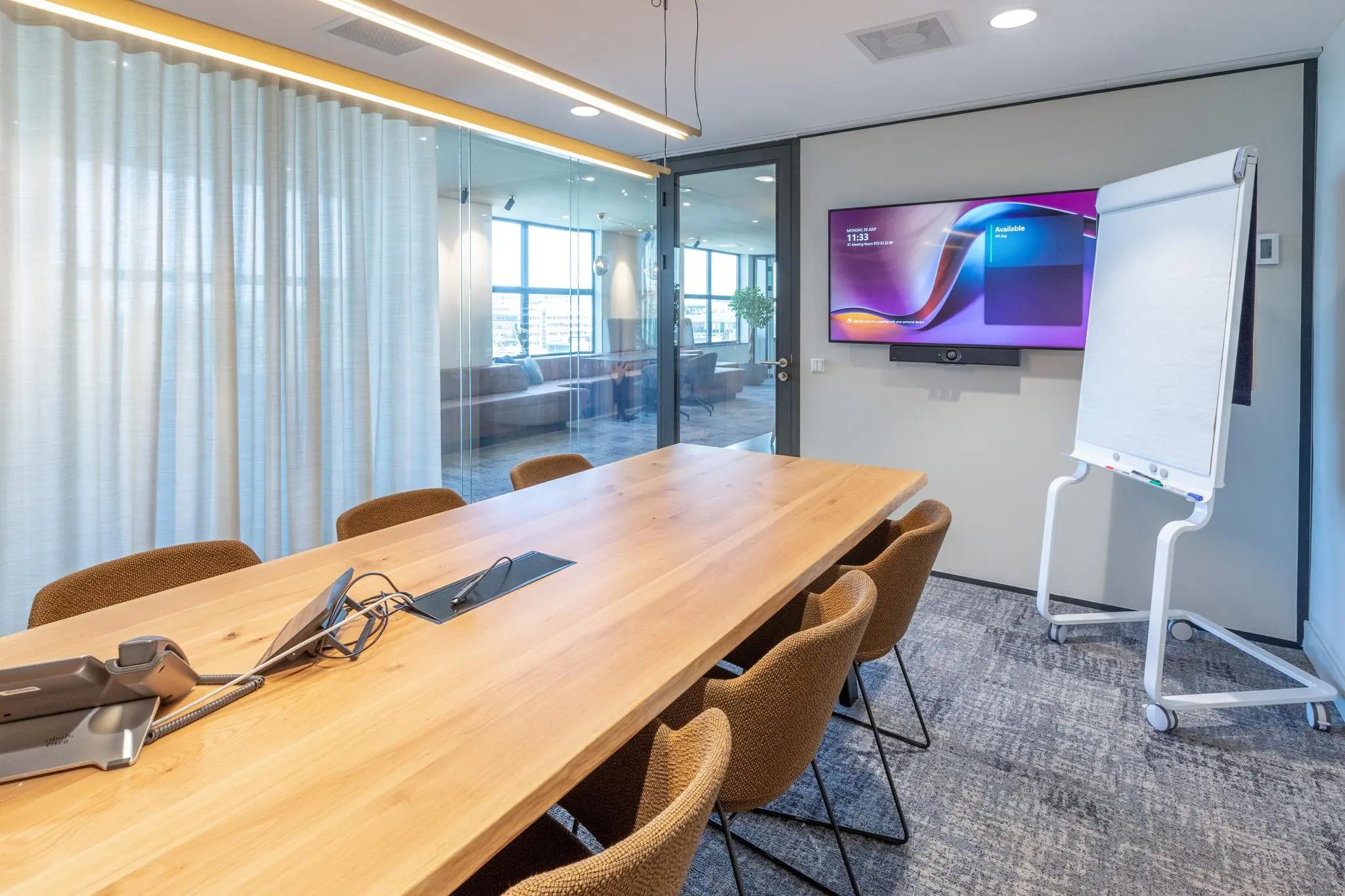 Moderne vergaderruimte in Weena met houten tafel, presentatiescherm en flip-over.