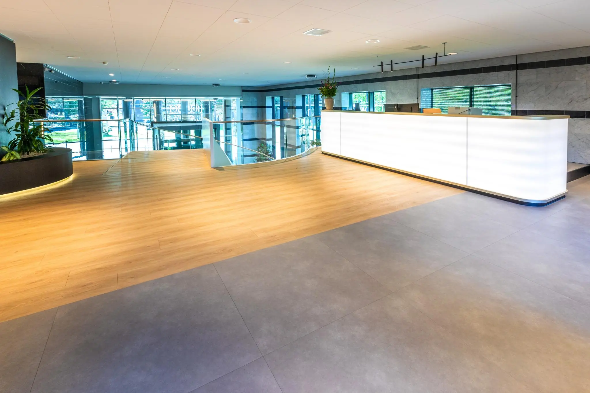 Moderne en lichte ontvangstbalie in de hal van een kantoorgebouw aan het Weena.