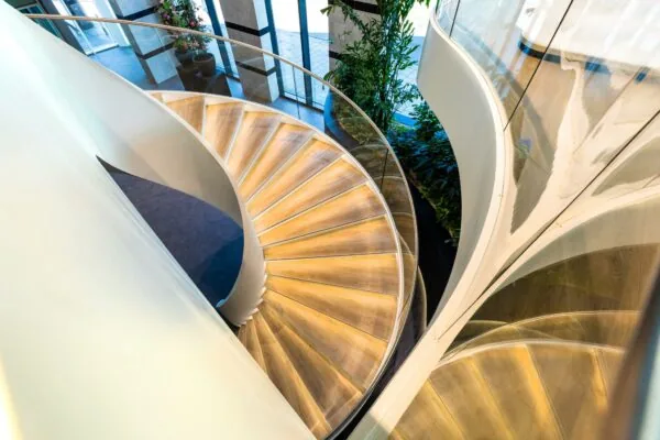 Moderne houten wenteltrap met glazen balustrade in het kantoorgebouw aan het Weena.