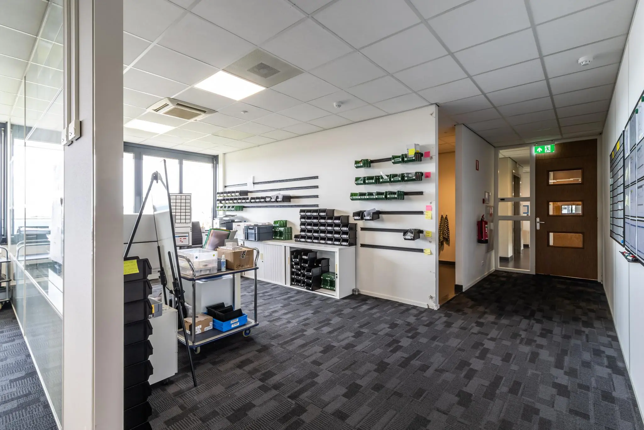 Goed georganiseerde werkruimte aan de Laanakkerweg met wandrekken, opbergsystemen en kantoorbenodigdheden.