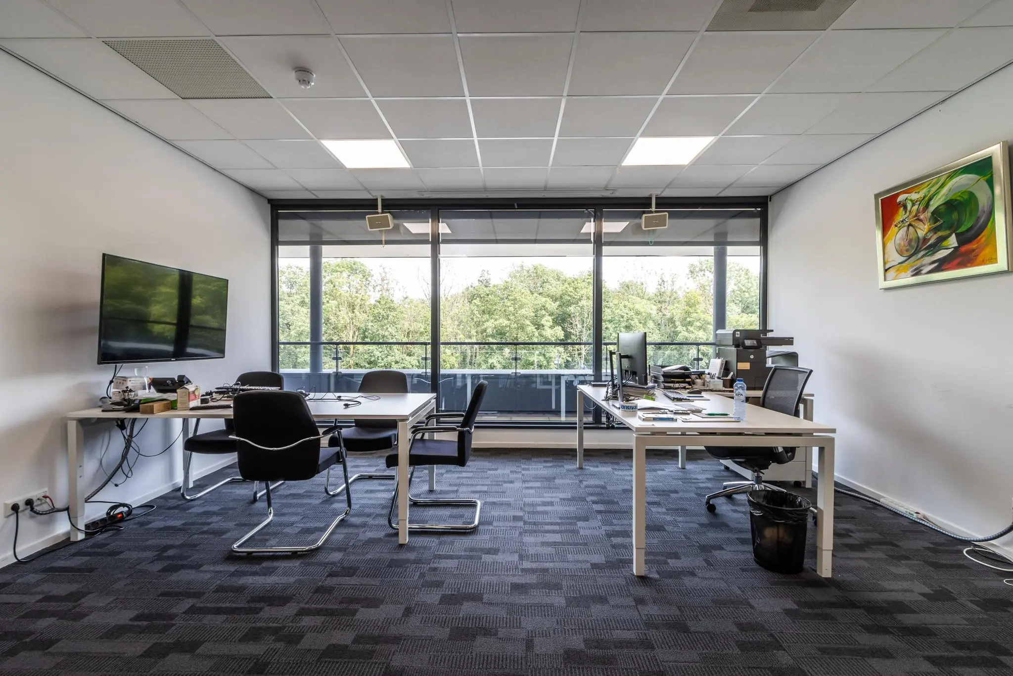 Moderne kantoorruimte aan de Laanakkerweg met vergadertafel, bureaus, grote ramen en uitzicht op groen.