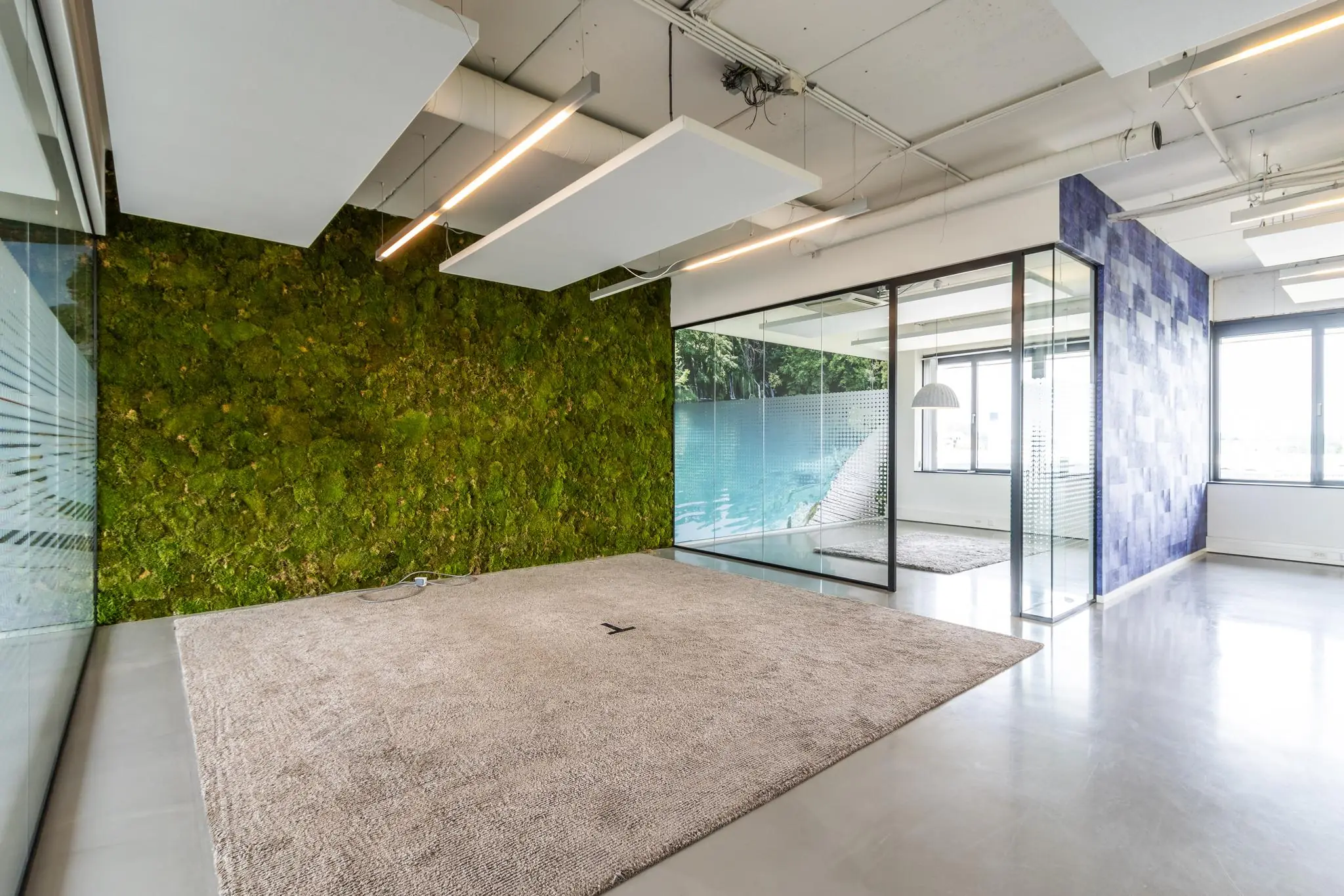 Moderne kantoorruimte aan de Laanakkerweg met moswand, glazen vergaderruimte en strakke afwerking.