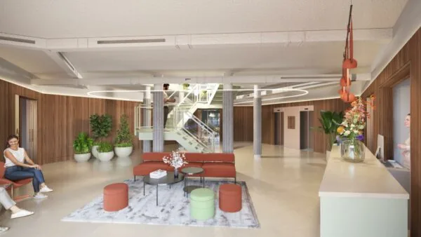 Moderne en sfeervolle lobby op Fleminglaan met zitgelegenheid, receptiebalie, planten en een centrale trap.