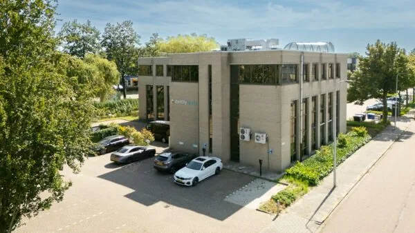 Kantoorpand van Identity Workx aan de Ligusterbaan met geparkeerde auto's op de voorgrond.