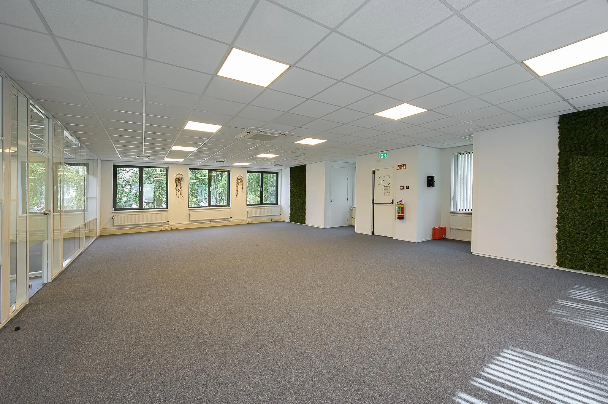 Ruim en licht kantoorpand aan de Ligusterbaan met grote ramen, systeemplafond en moswand.