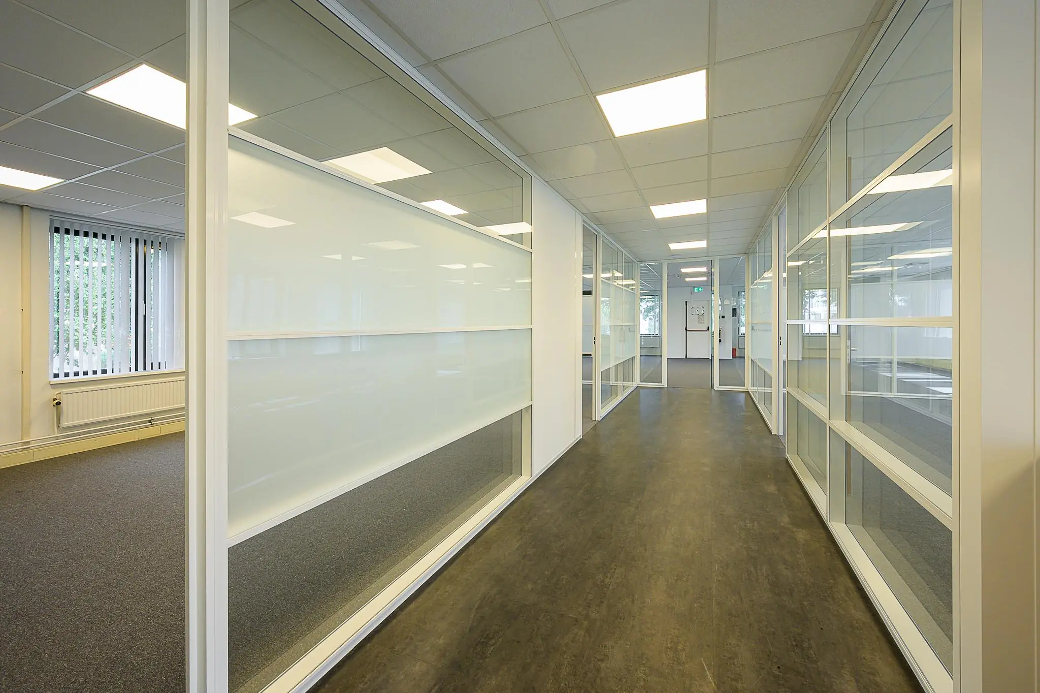 Lichte, moderne kantoorruimte aan de Ligusterbaan met glazen wanden en systeemplafond.