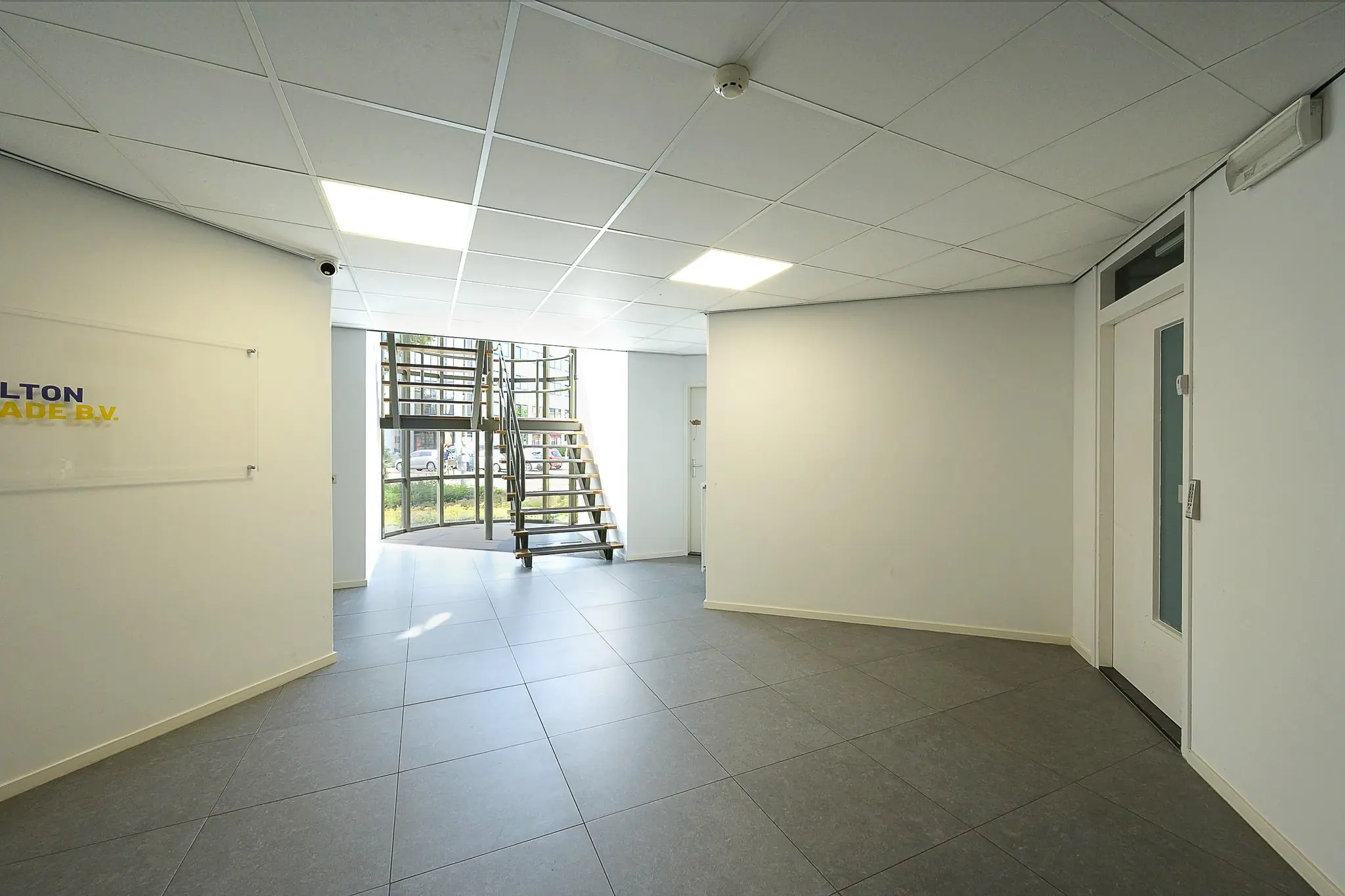 Moderne, lichte entreehal met trap en groot raam aan de Ligusterbaan.