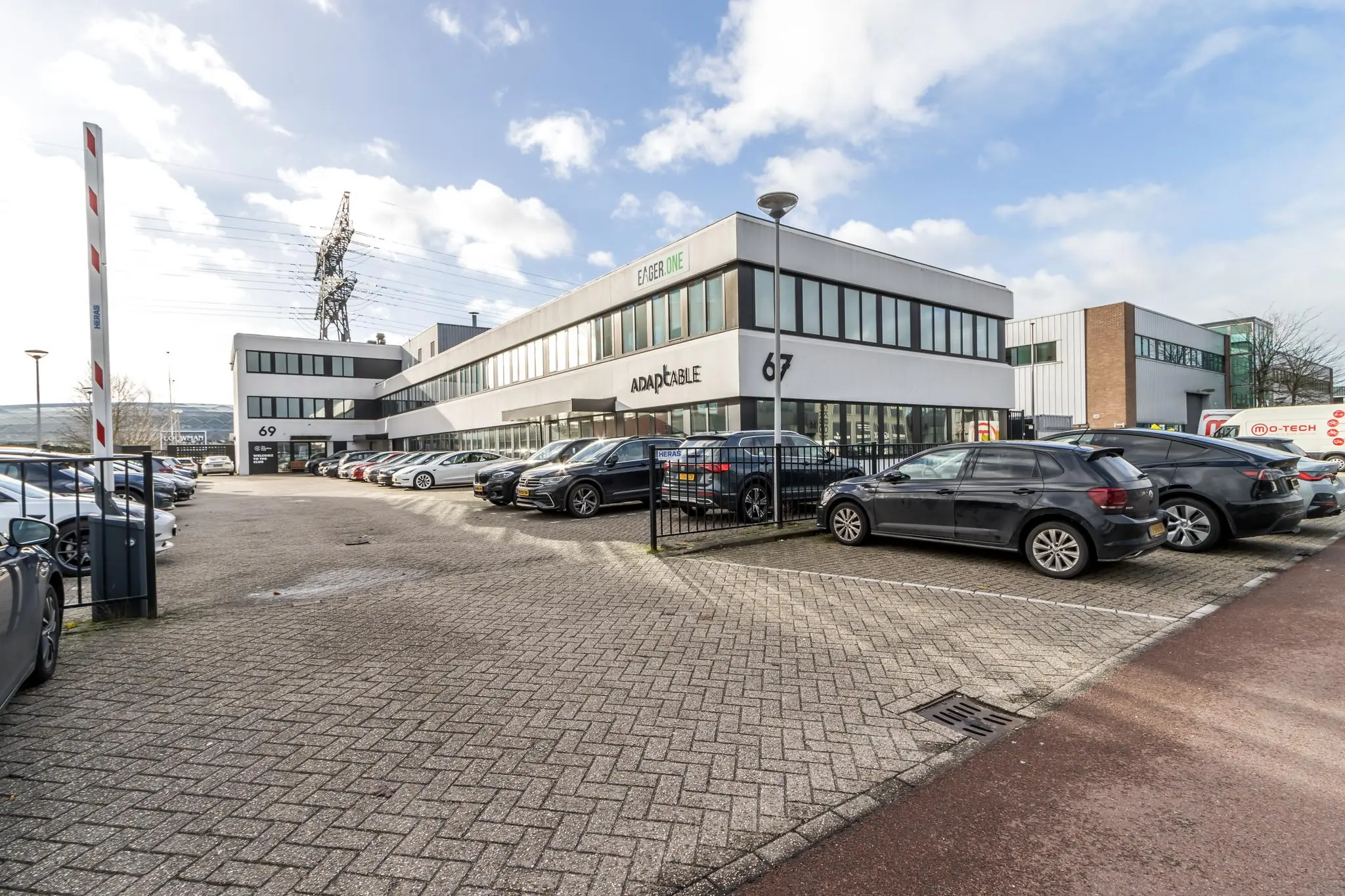 Kantoorpand aan de Savannahweg 67-69 in Utrecht met geparkeerde auto's op de parkeerplaats.