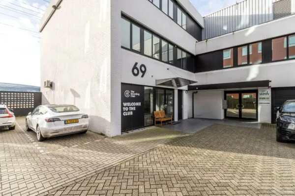 Vooraanzicht van een modern kantoorgebouw aan de Savannahweg 69 met bedrijfsentrees van The Branding Club en MZGN.