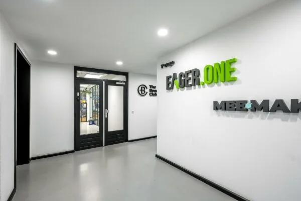 Ingang van een modern kantoorpand aan de Savannahweg met bedrijfsnamen zoals Eager.One en The Brand Club op de muur.