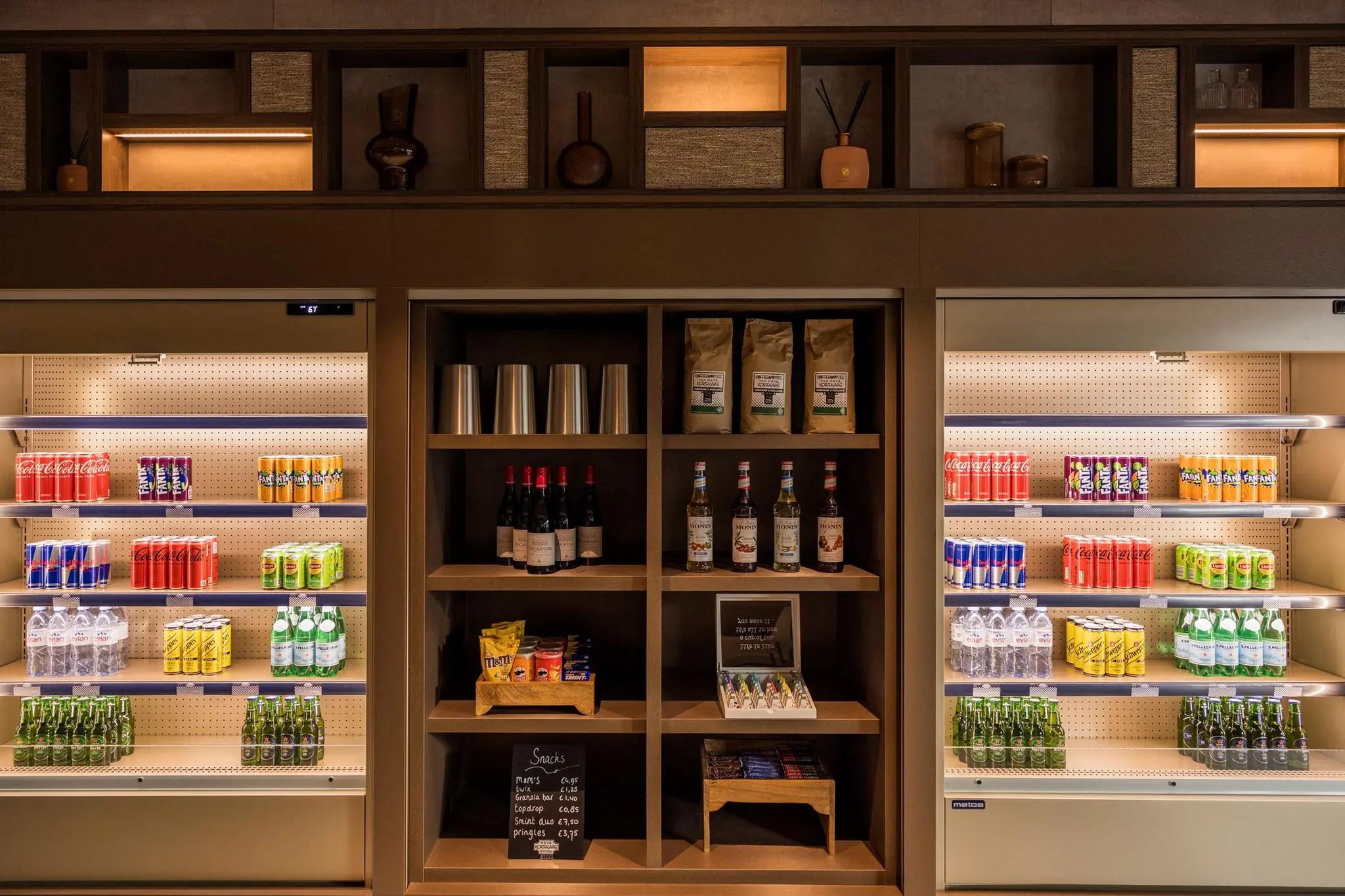 Koelkast en schappen met drankjes, snacks en koffiebenodigdheden in Diemerhof.