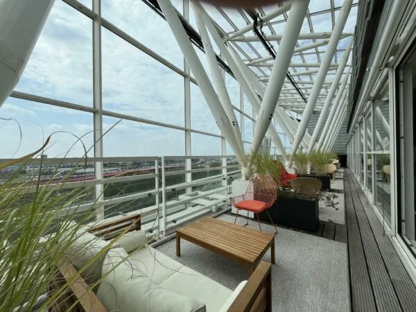 Overdekt dakterras met moderne zitmeubels en uitzicht op bedrijventerrein aan de Reactorweg.