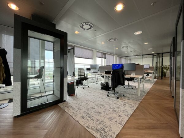 Modern kantoorinterieur aan de Reactorweg met werkplekken, een belcel en grote ramen met uitzicht.