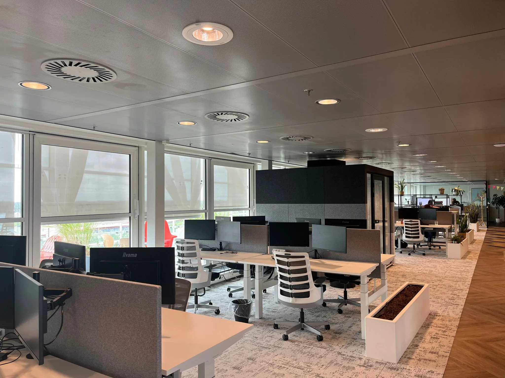Moderne open kantoorruimte aan de Reactorweg met meerdere werkplekken, bureaustoelen en plantenbakken.