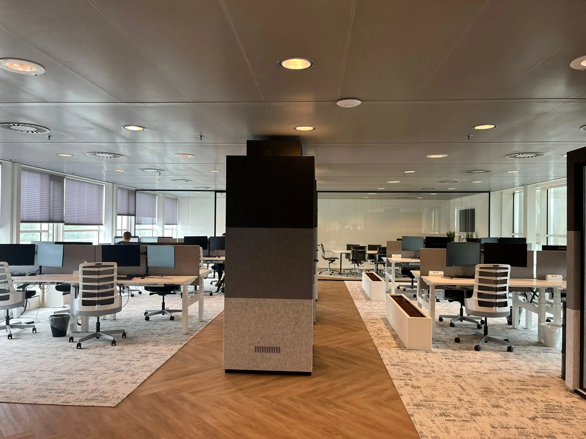 Moderne, open kantoorruimte aan de Reactorweg met bureaus, beeldschermen en ergonomische bureaustoelen.