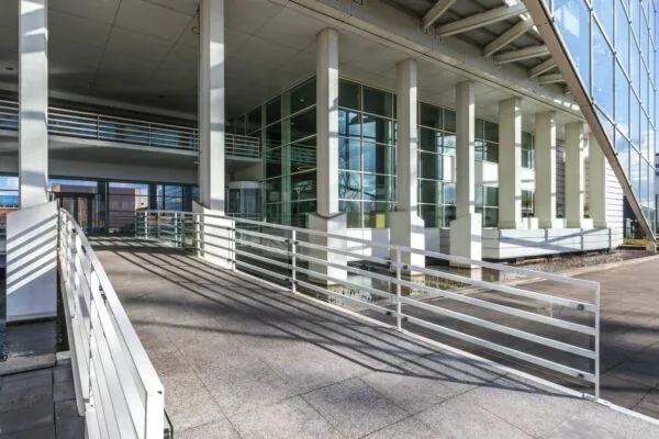 Entree van een modern kantoorgebouw aan de Reactorweg met witte zuilen en glazen gevel.