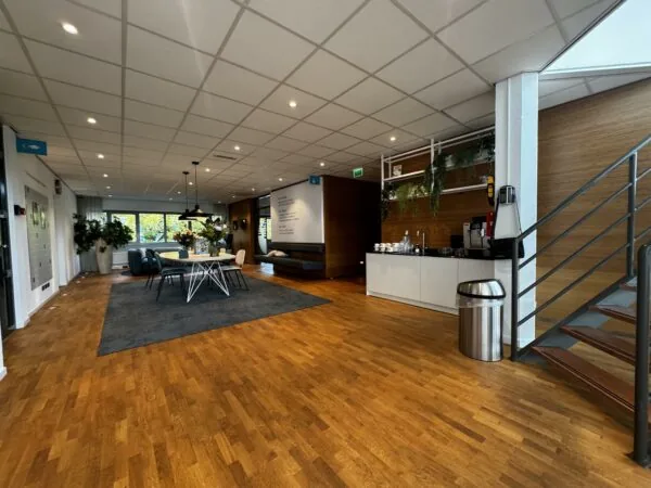 Moderne kantoorruimte aan de Softwareweg met zithoek, vergadertafel, koffiecorner en trap naar boven.