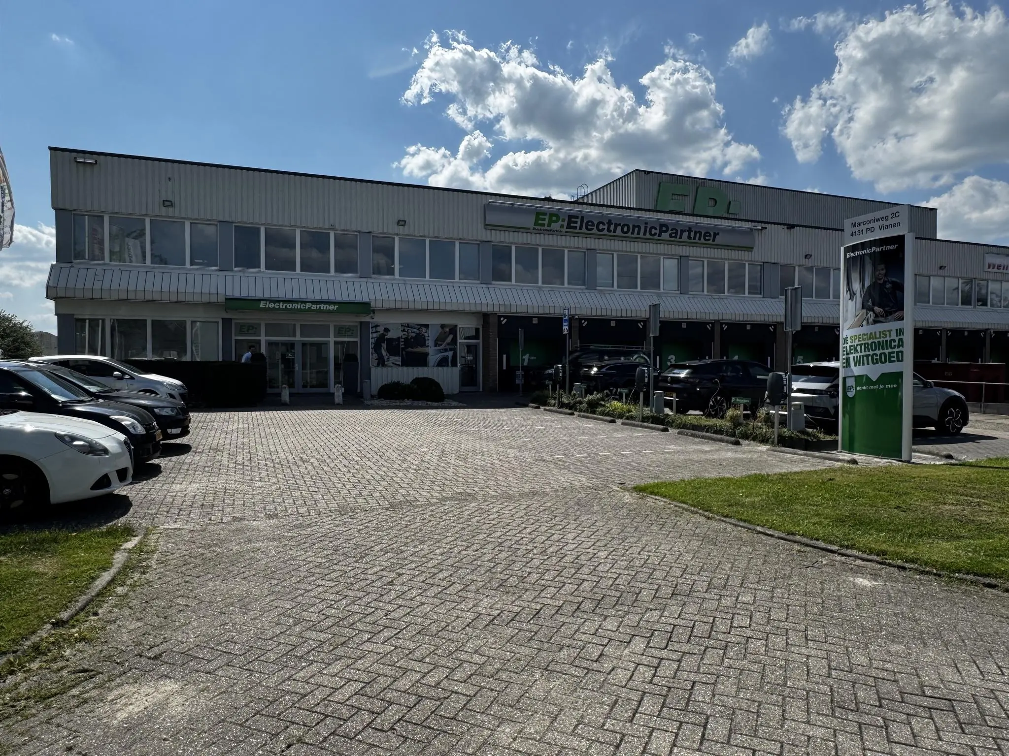 Vooraanzicht van het EP:ElectronicPartner winkelpand aan de Lorentzweg in Vianen, met geparkeerde auto's op de parkeerplaats.