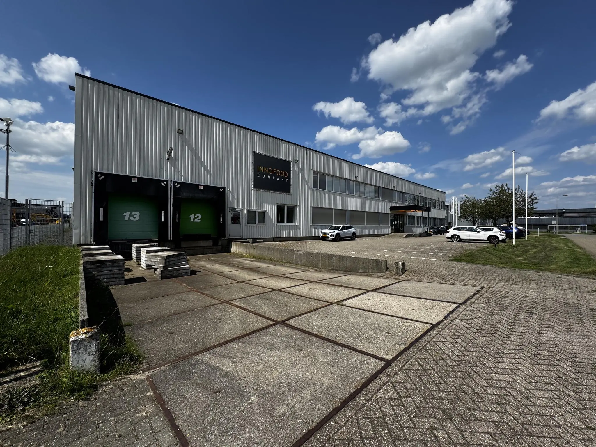 Vooraanzicht van het bedrijfsgebouw van Innofood Company aan de Lorentzweg, met laadperrons en geparkeerde auto's.