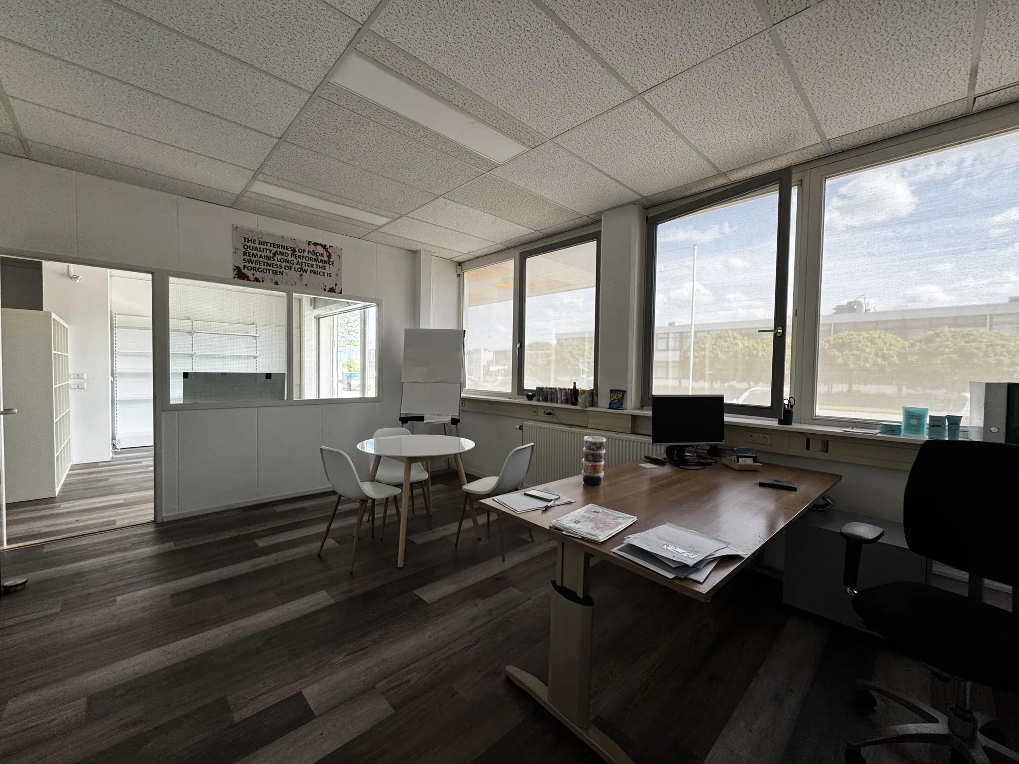 Modern ingericht kantoor aan de Lorentzweg met bureau, vergadertafel en grote ramen met daglicht.