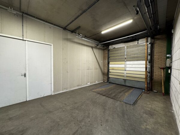 Leeg industriëel laadperron met gesloten overheaddeur aan de Lorentzweg.