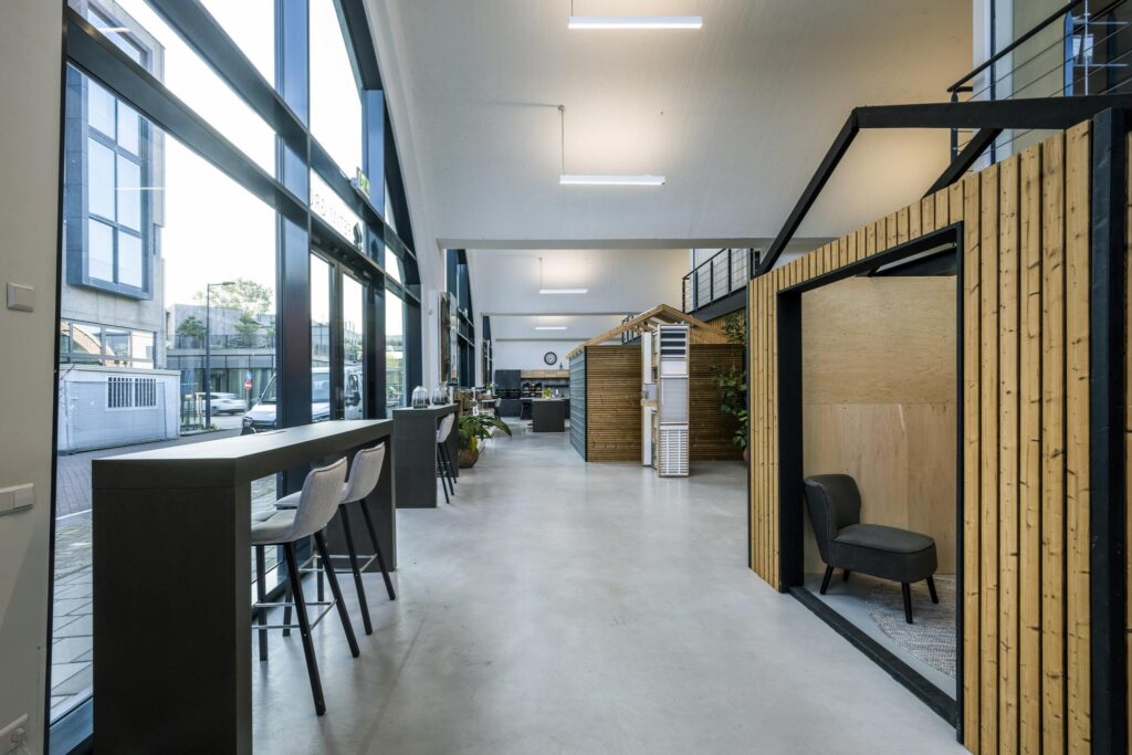 Moderne kantoorruimte aan de Abram Dudok van Heelstraat met hoge ramen, houten werkpods en een minimalistisch interieur.