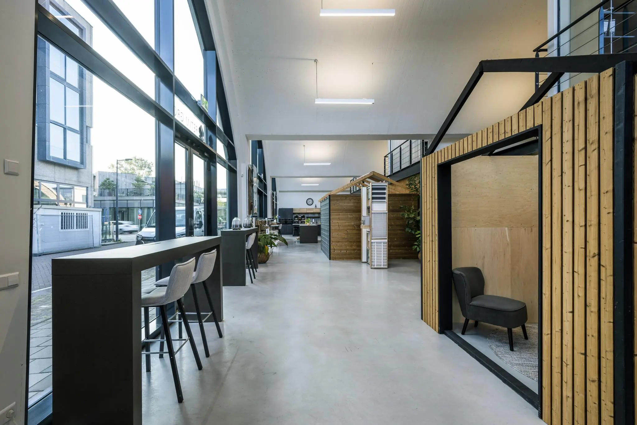 Moderne kantoorruimte aan de Abram Dudok van Heelstraat met hoge ramen, houten werkpods en een minimalistisch interieur.