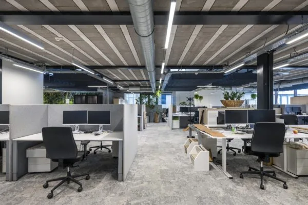 Moderne open kantoorruimte aan de Abram Dudok van Heelstraat met werkplekken, bureaustoelen en veel natuurlijk licht.