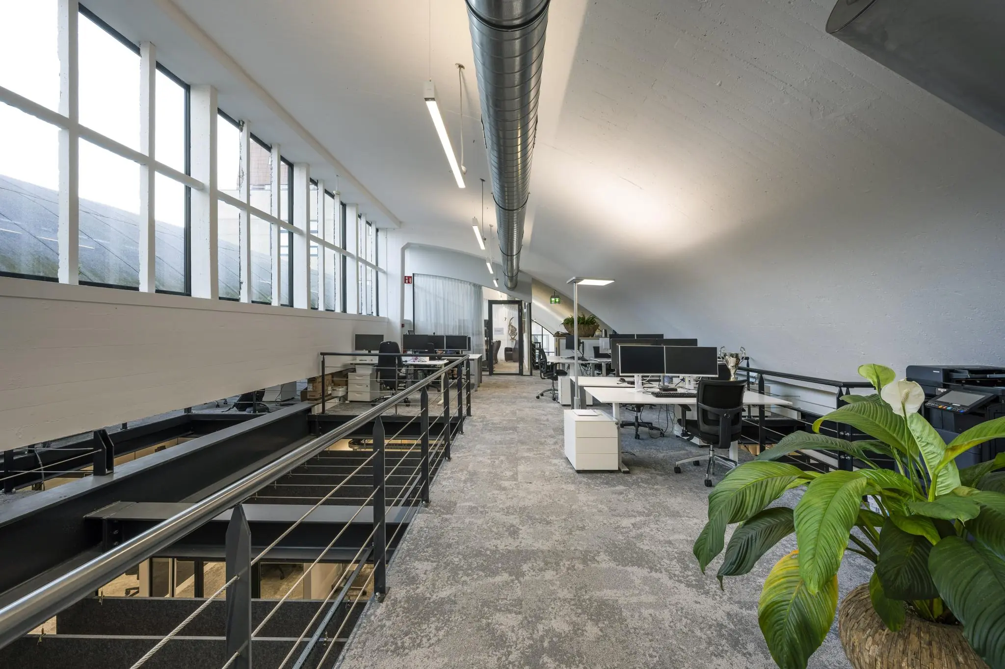 Moderne kantoorruimte op de Abram Dudok van Heelstraat met open werkplekken, schuine plafonds en grote ramen.