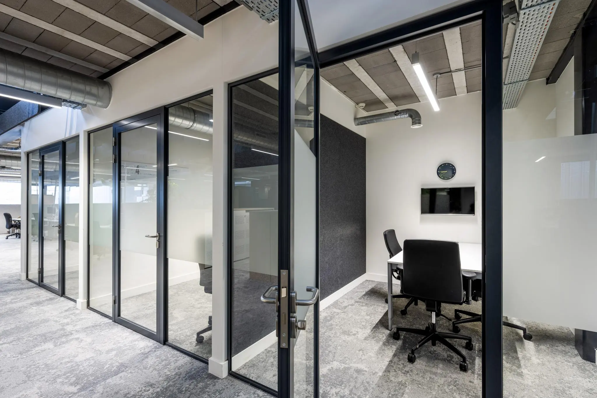 Moderne kantoorruimte aan de Abram Dudok van Heelstraat met glazen wanden, bureaustoelen en een vergadertafel.