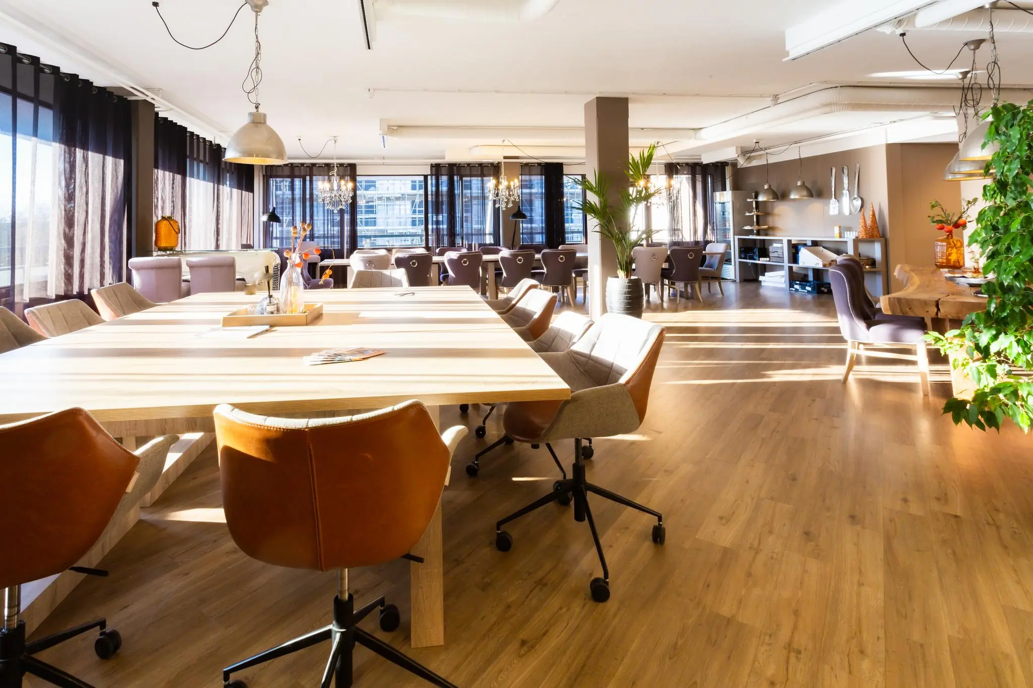 Licht en modern ingericht vergaderruimte aan de Zaagmolenlaan met grote houten tafels, comfortabele stoelen en veel natuurlijk licht.