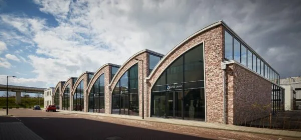Modern bedrijfsgebouw met opvallende gebogen daken aan de Abram Dudok van Heelstraat, met het logo van Fetim Group op de gevel.