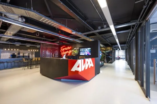 Moderne receptiebalie met het logo van AWA en een neonbord met de tekst "Forever Young" in een kantoor aan de Anthony Fokkerweg.