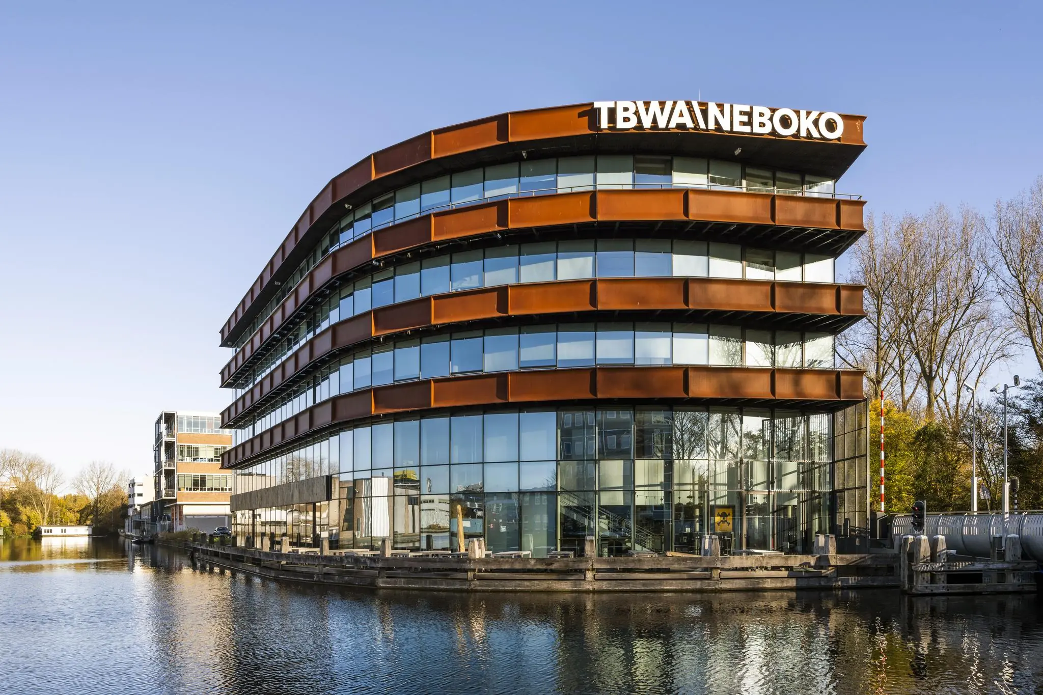 Modern kantoorgebouw van TBWANEBOKO aan het water aan de Generaal Vetterstraat in Amsterdam.