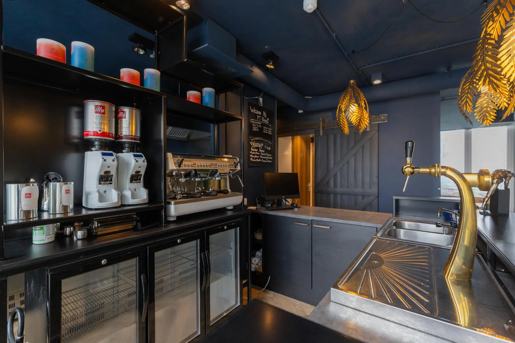 Moderne koffie- en barhoek in MandelaPlein met espressomachine, bierkraan en sfeerverlichting.