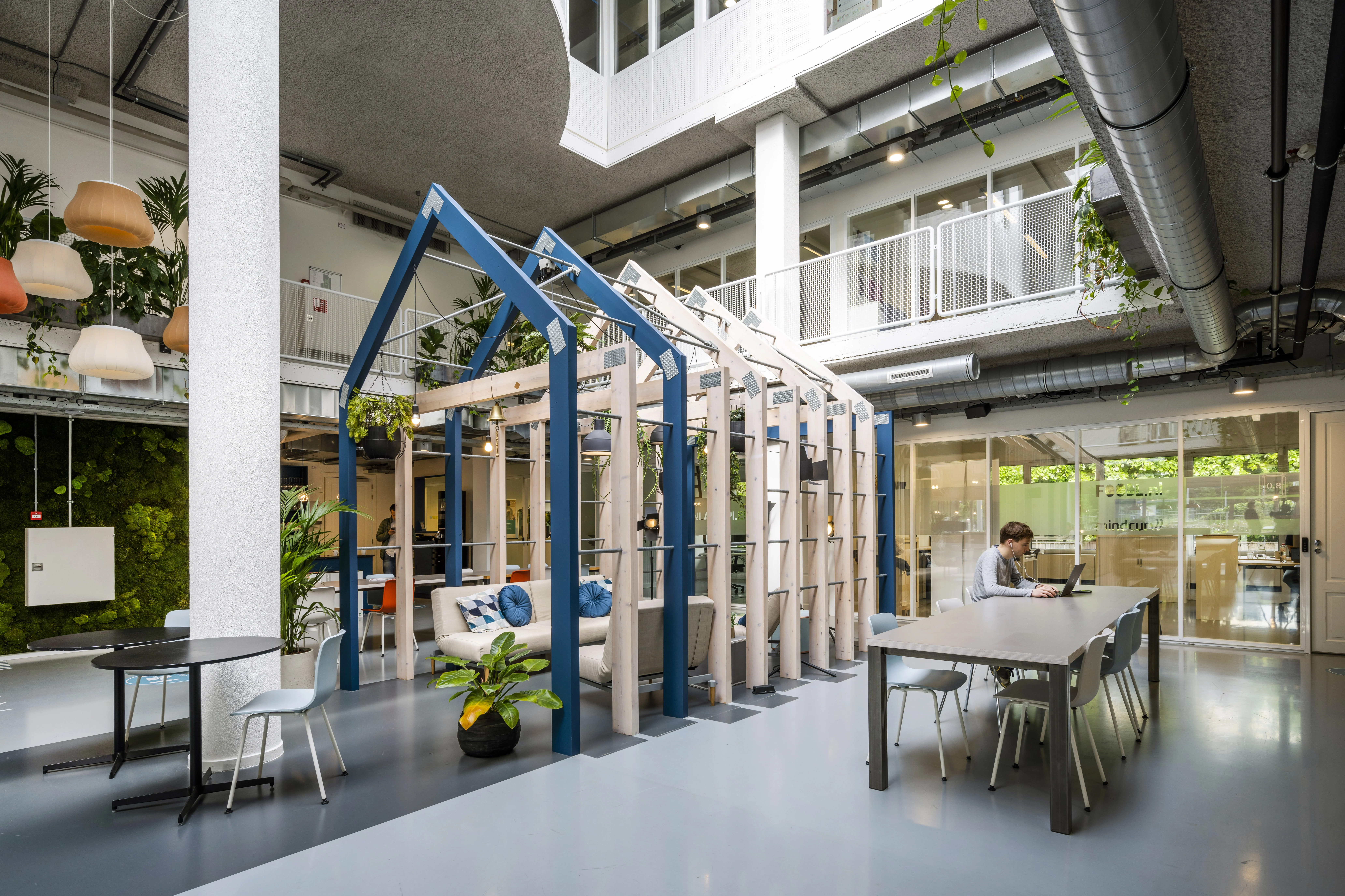Moderne en open werkruimte in HNK Utrecht West met houten constructie, planten en zitplekken.