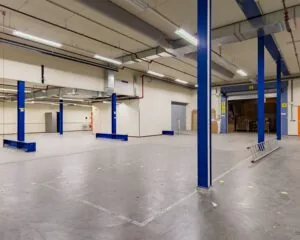 Ruime, lege kantoor- of bedrijfsruimte met blauwe kolommen aan de Albert Einsteinweg 5 in Lelystad.