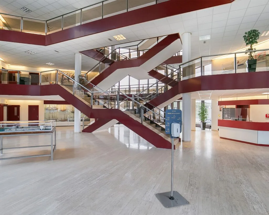 Moderne entreeruimte met een opvallend rood trappenhuis in het kantoorgebouw aan de Bolderweg 1 in Almere.